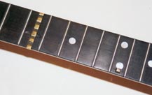 Brass bar flush with fretboard.